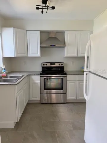 a kitchen with stainless steel appliances white cabinets and white appliances