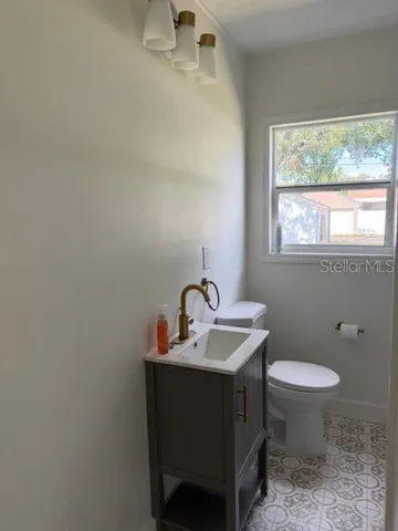 a bathroom with a toilet a sink and a window