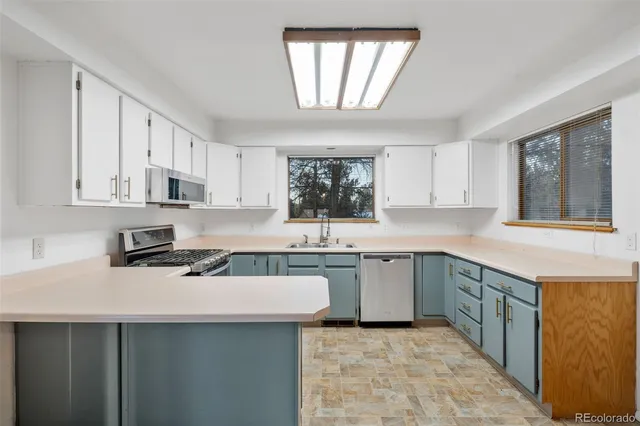 a kitchen with a sink window and cabinets