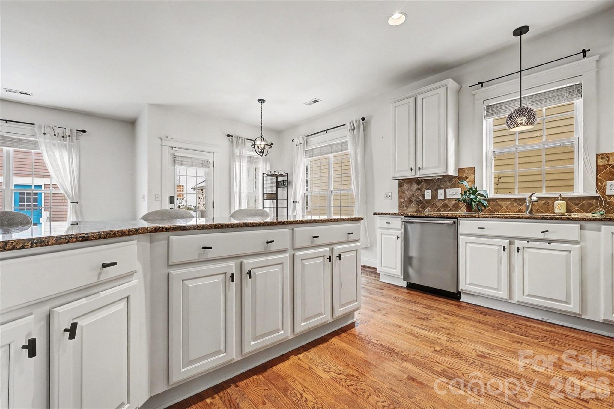 191 Lilac Mist Loop Mooresville, NC 28115 - Photo 14 of 44 a kitchen with granite countertop white cabinets white appliances a sink and a window