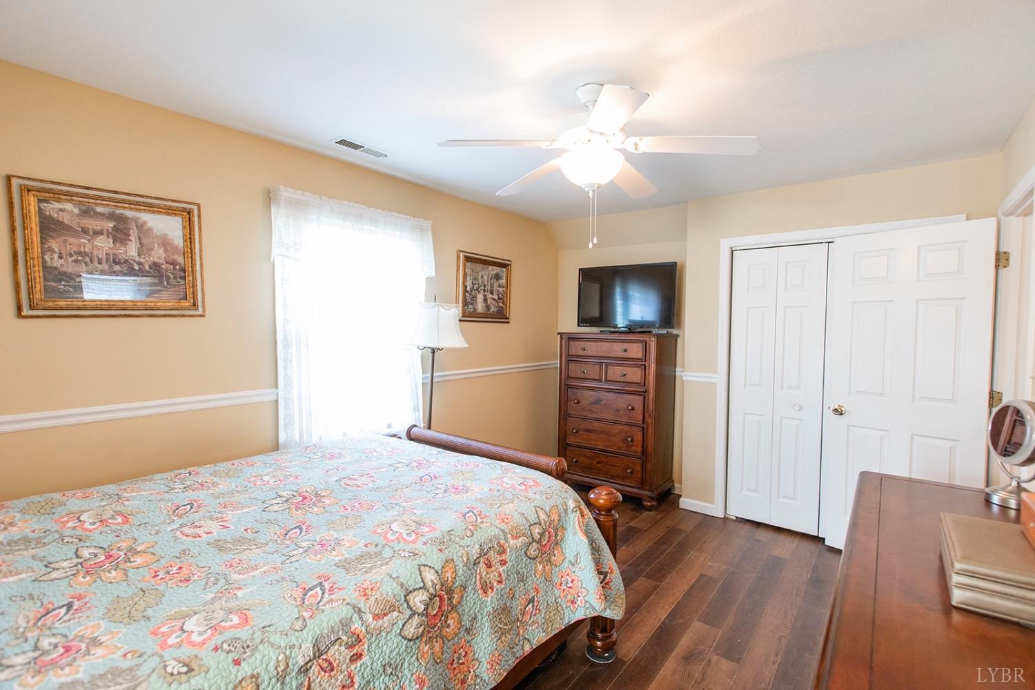 115 Hunters Creek Road Forest, VA 24551 - Photo 29 of 43 a bedroom with a bed and a chandelier