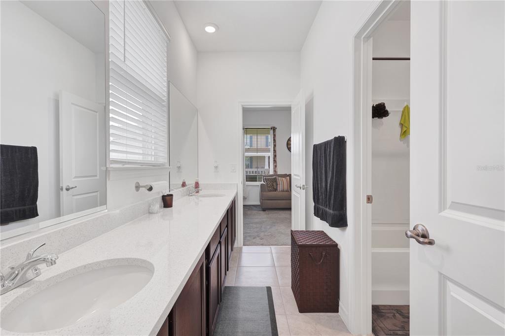 7185 Southwest 63rd Street Ocala, FL 34474 - Photo 25 of 31 a en suite bathroom with a double vanity sink and mirror