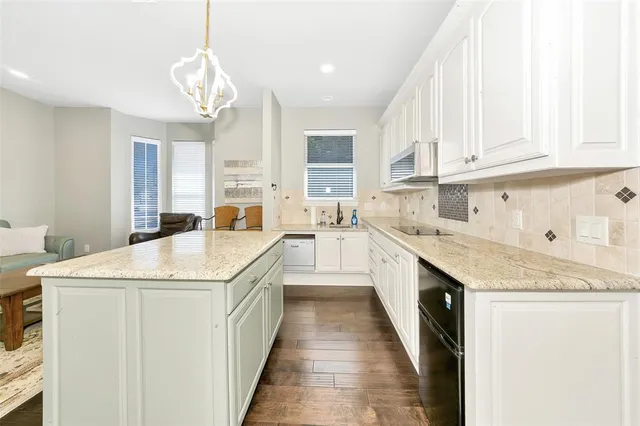 a kitchen with granite countertop a sink stove and cabinets