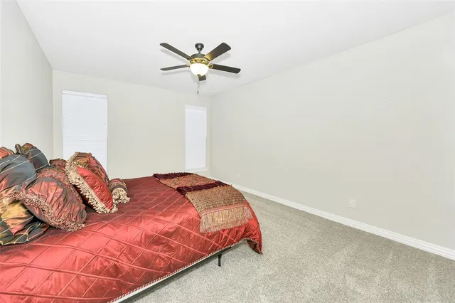 a bedroom with a bed and a painting on the wall