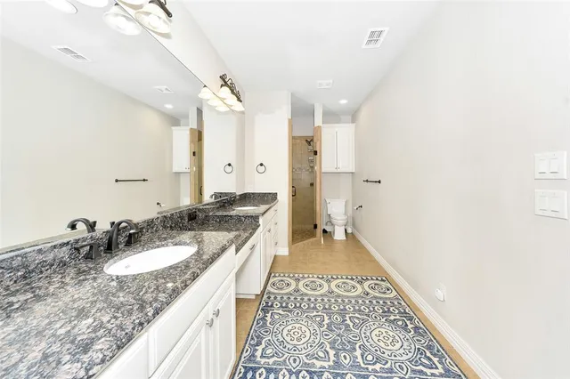 a spacious bathroom with a granite countertop sink and a mirror