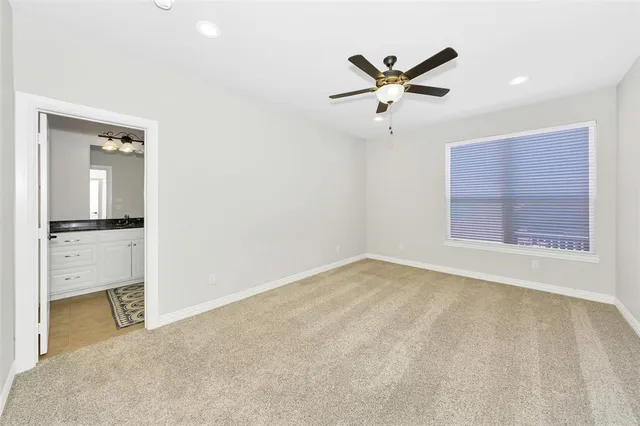 a view of an empty room with cabinet and a ceiling fan
