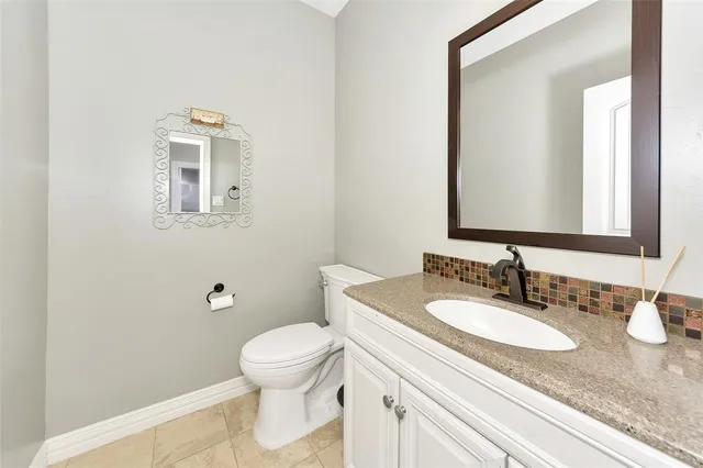 a bathroom with a granite countertop sink toilet and a mirror
