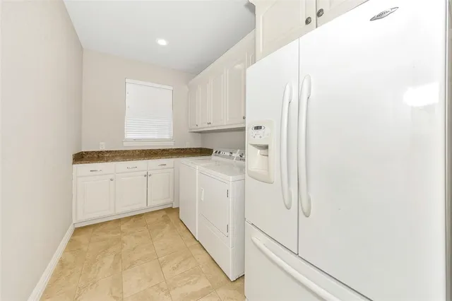 a kitchen with white cabinets and white appliances