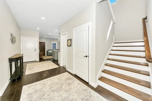 a view of entryway with kitchen and hall with wooden floor
