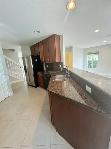 a kitchen with a refrigerator and a stove top oven