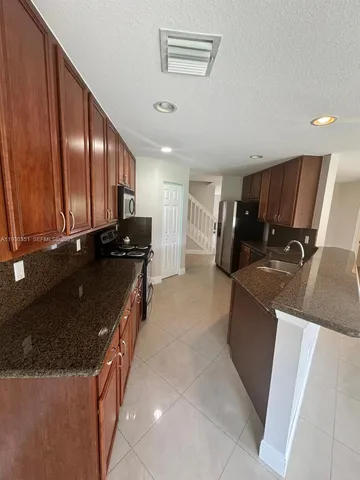 a kitchen with granite countertop sink and cabinets