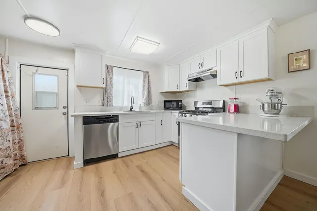 a kitchen with stainless steel appliances granite countertop a sink and cabinets