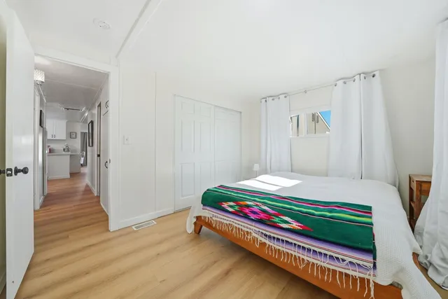 a room with a bed and wooden floor