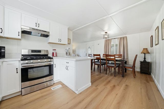 a kitchen with a white stove top oven and cabinets