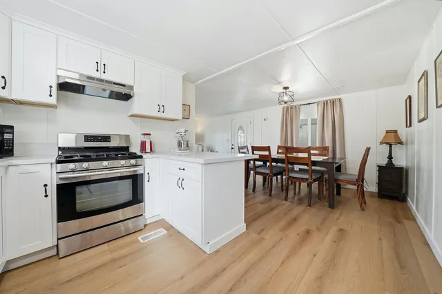 a kitchen with a white stove top oven and cabinets