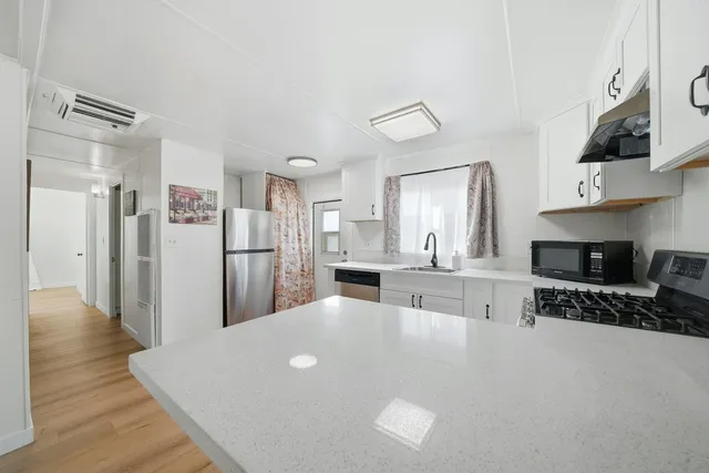 a kitchen with stainless steel appliances a refrigerator and a stove top oven