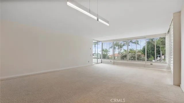 a view of a room with a large window and kitchen view