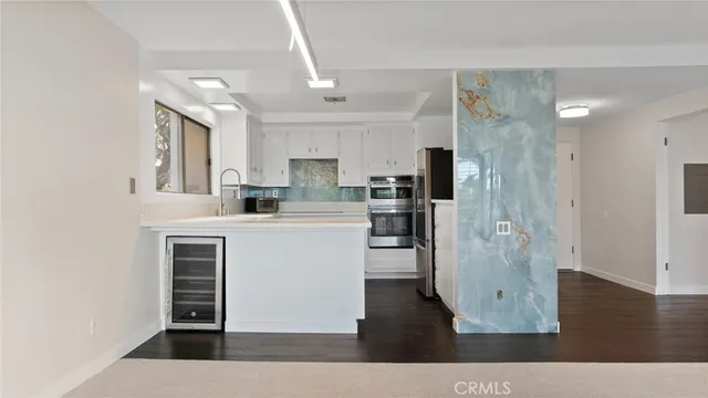 a kitchen with stainless steel appliances granite countertop a refrigerator and a stove top oven