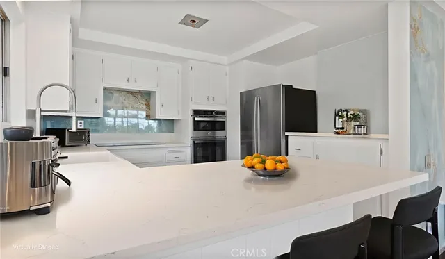 a white kitchen with a stove a sink dishwasher and a refrigerator