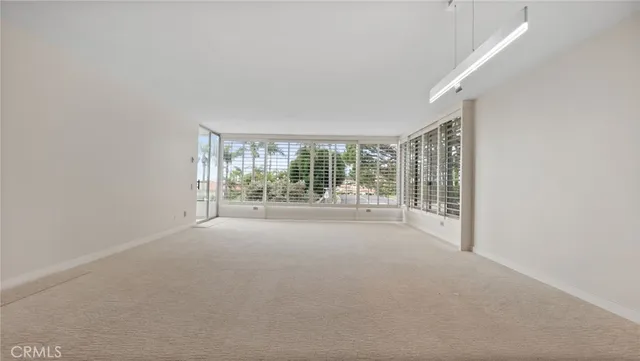 a living room with furniture a flat screen tv and floor to ceiling window