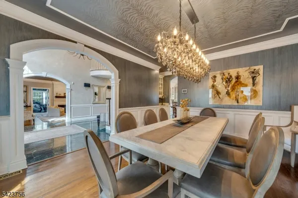 a dining room with furniture a chandelier and wooden floor
