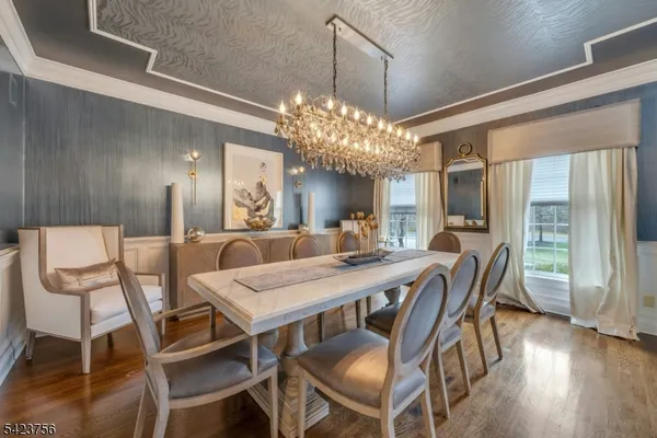 a view of a dining room with furniture a chandelier and wooden floor