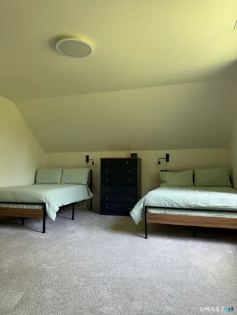a spacious bedroom with a bed and a desk in it