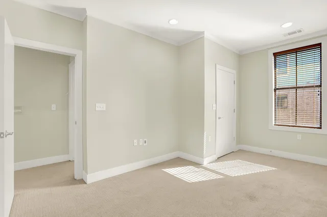 a view of a big room with wooden floor and windows