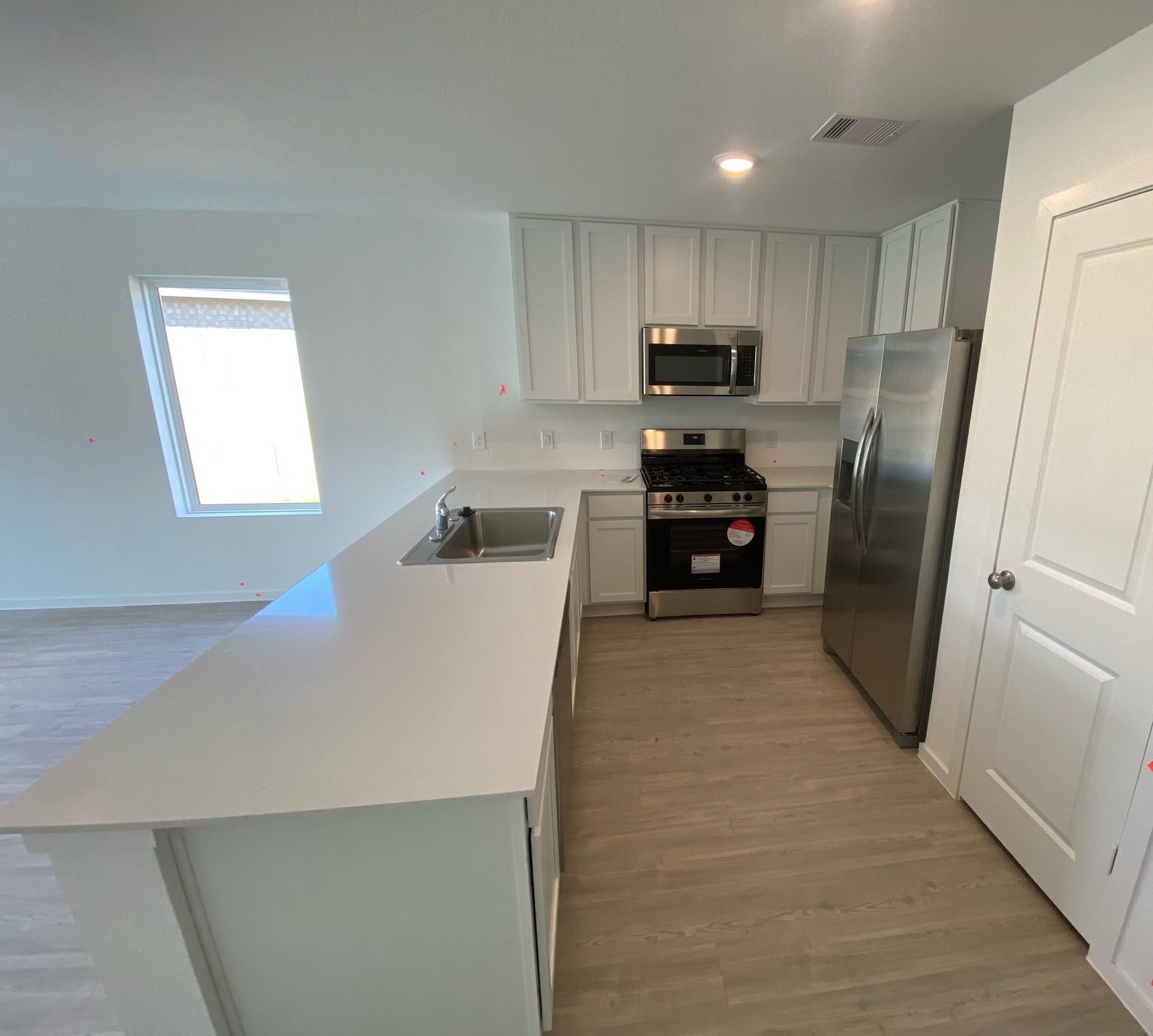 16511 Ithaca Pheasant Drive New Caney, TX 77357 - Photo 4 of 31 a kitchen with cabinets a refrigerator and a sink