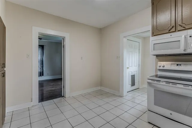 a kitchen with white cabinets and appliances