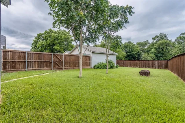 a backyard of a house with lots of plants and tree