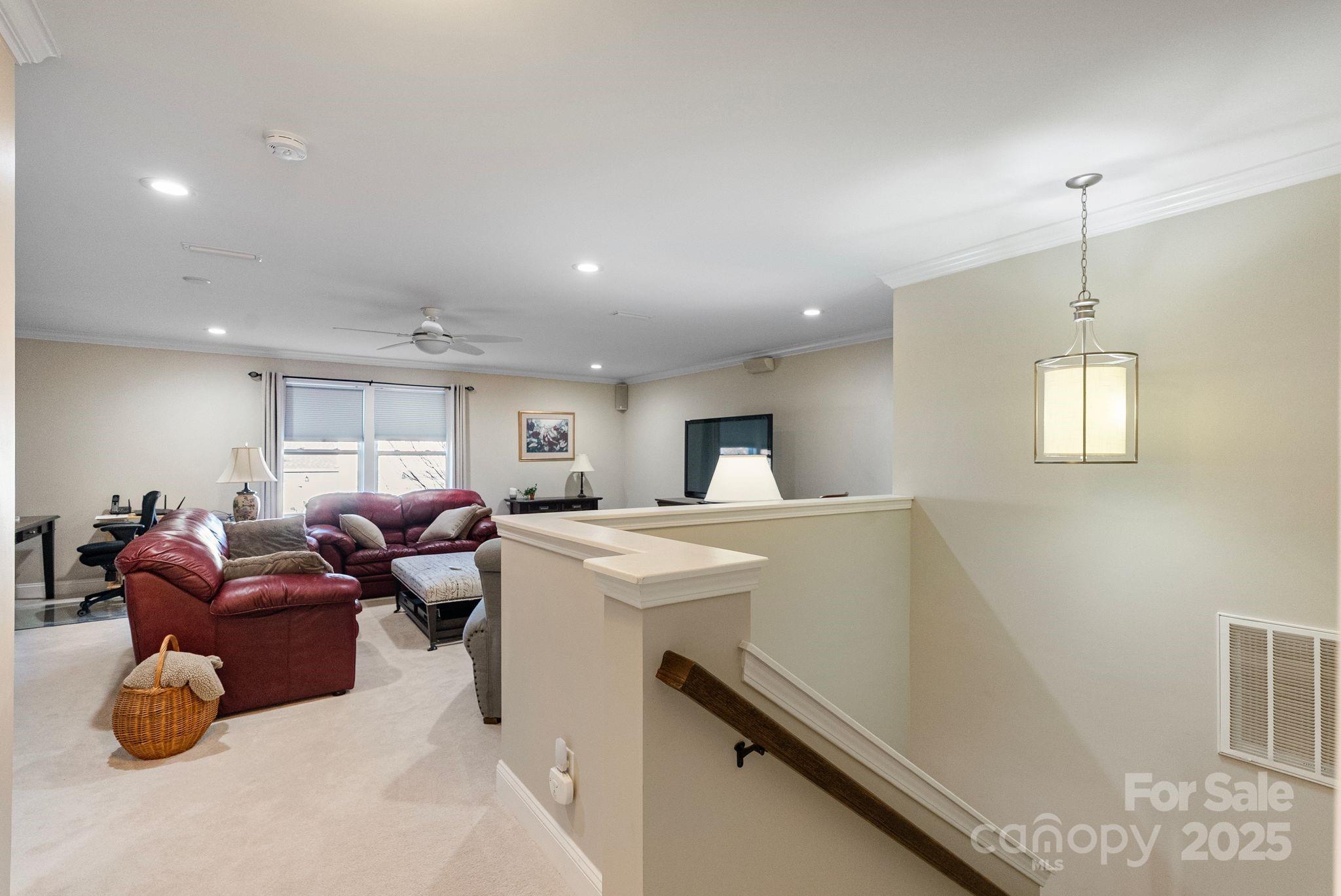 2304 Celandine Way Tega Cay, SC 29708 - Photo 28 of 47 a living room with furniture a window and a chandelier