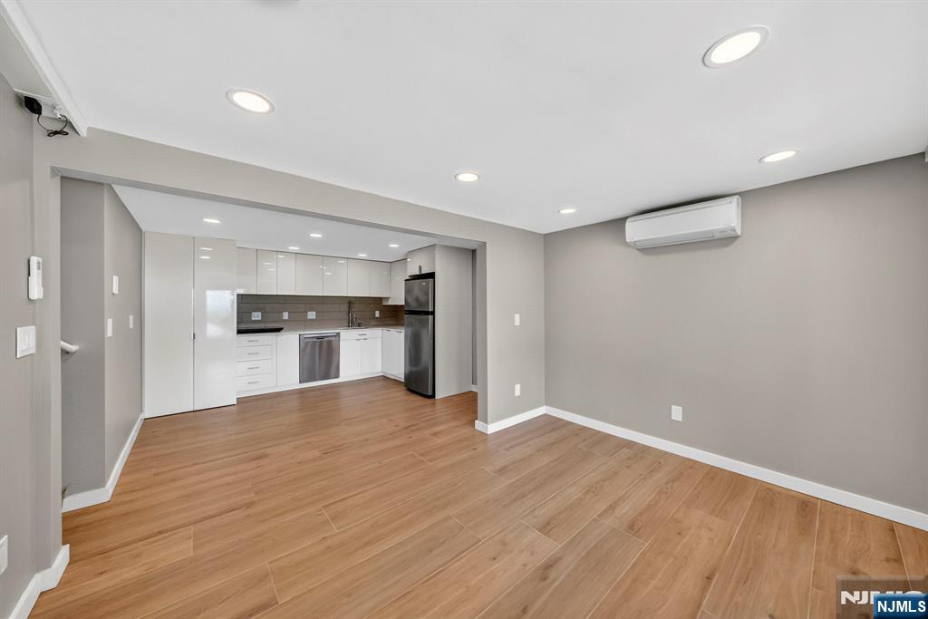 57 Hemlock Road Little Falls, NJ 07424 - Photo 34 of 50 a view of an empty room with wooden floor and a kitchen