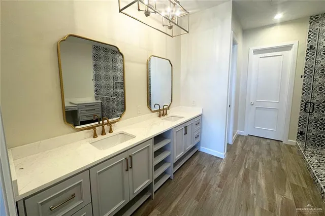 a bathroom with a double vanity sink mirror and shower