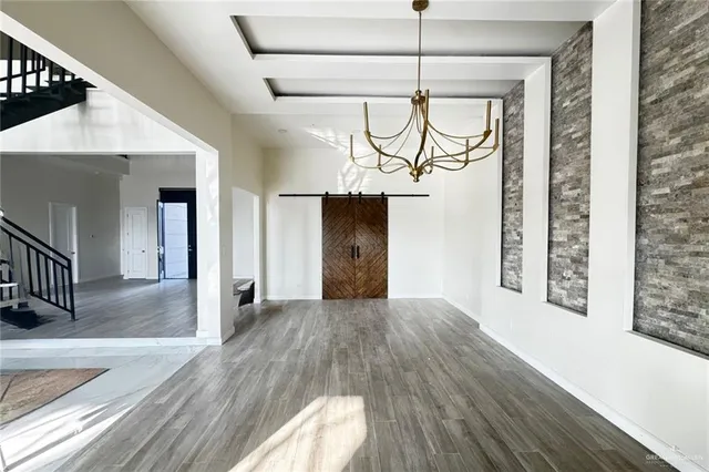 a view of a hallway with wooden floor and front door