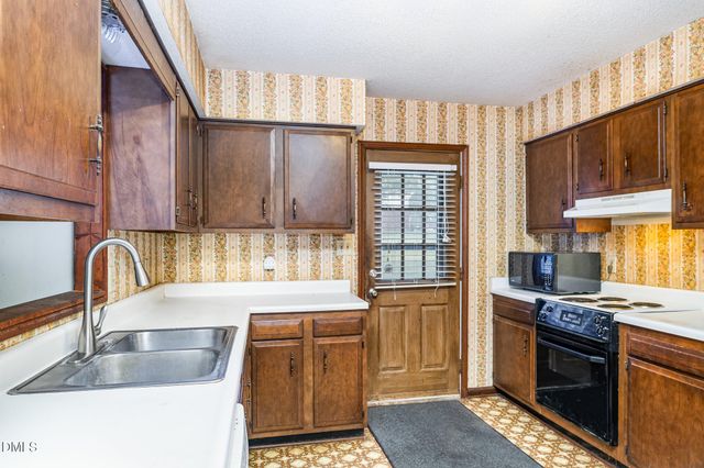 a kitchen with a sink a counter top space and stainless steel appliances