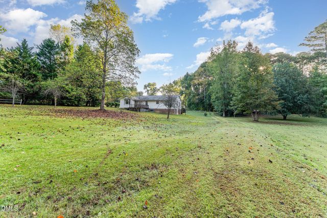 a aerial view of a house next to a yard with big trees