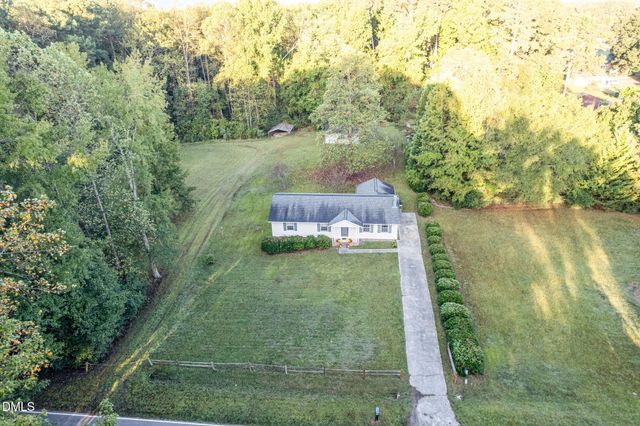 a view of a big house with a big yard and large trees