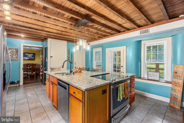 a view of a dining room with furniture a chandelier and large windows