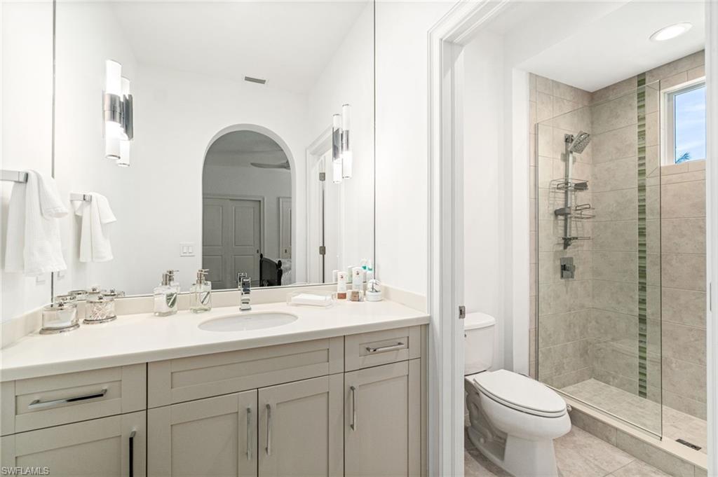 16755 Lucarno Way Naples, FL 34110 - Photo 20 of 50 a bathroom with a double vanity sink mirror and toilet