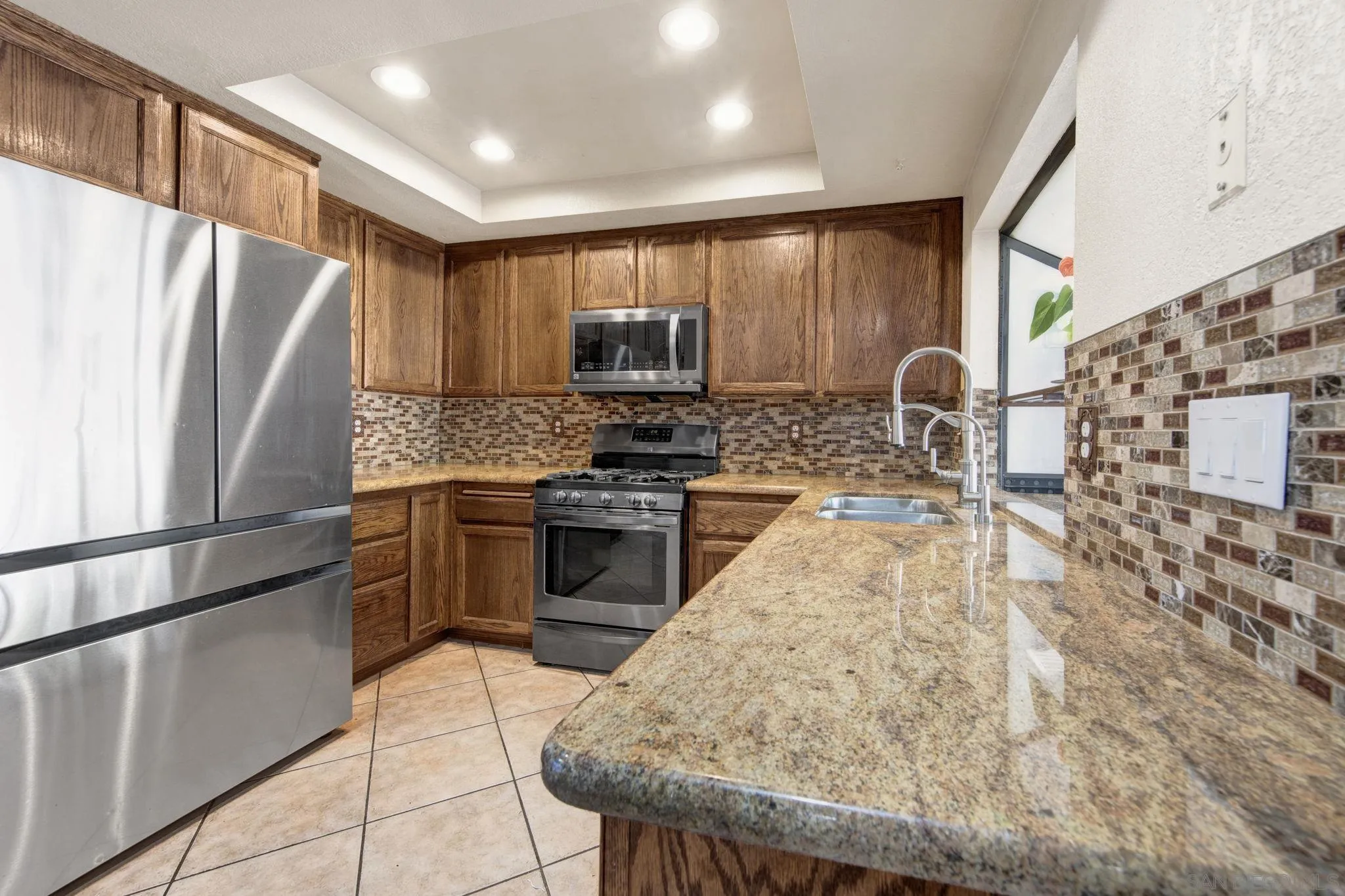 2772 Cincinnati Street West San Bernardino, CA 92407 - Photo 12 of 41 a kitchen with granite countertop a refrigerator stove top oven and sink
