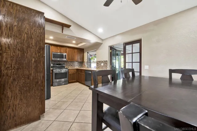 a kitchen with a table chairs refrigerator and cabinets