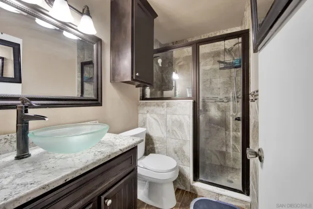 a bathroom with a granite countertop sink toilet and shower