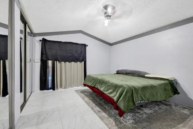 a bedroom with a bed next to a window