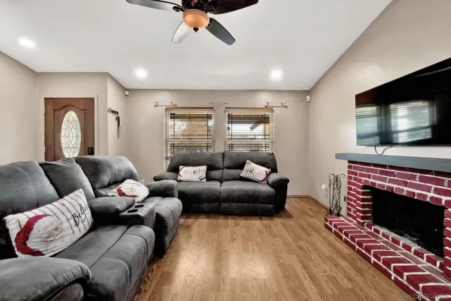 a living room with furniture a flat screen tv and a fireplace
