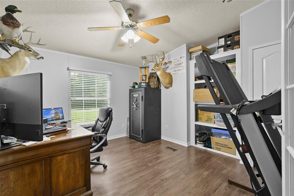338 Fisherman Road Pottsboro, TX 75076 - Photo 21 of 24 Wood-finish flooring, ceiling fan, built-in shelving, white trim, and a window with blinds