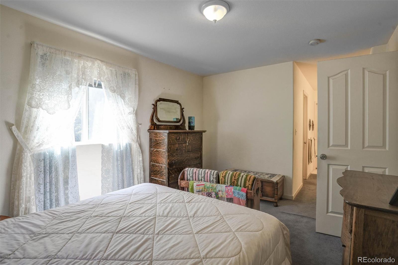 1206 Biddle Street Georgetown, CO 80444 - Photo 19 of 32 a bedroom with a bed and a fireplace