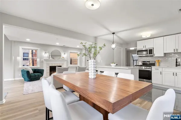 a large kitchen with sink a refrigerator and chairs