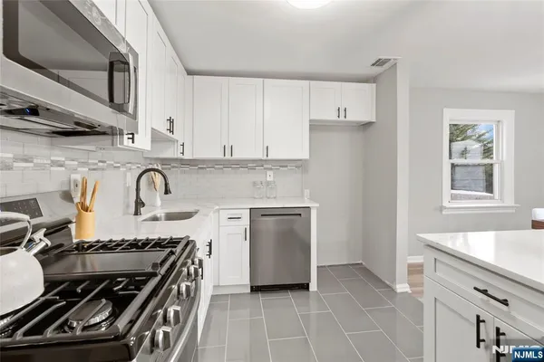 a kitchen with granite countertop a stove and a sink