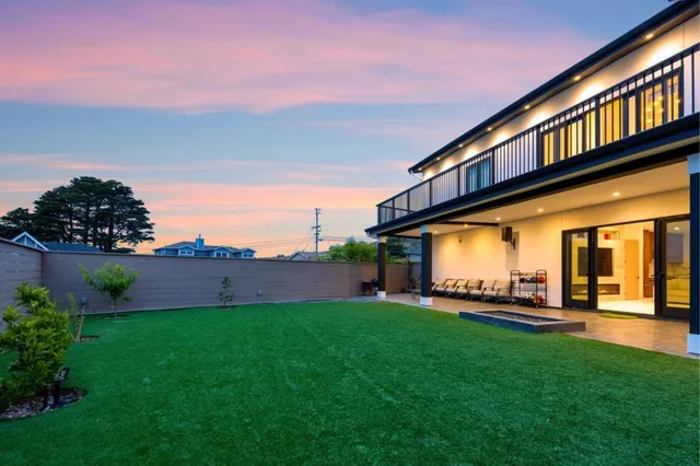 a backyard of a house with lots of green space and fountain